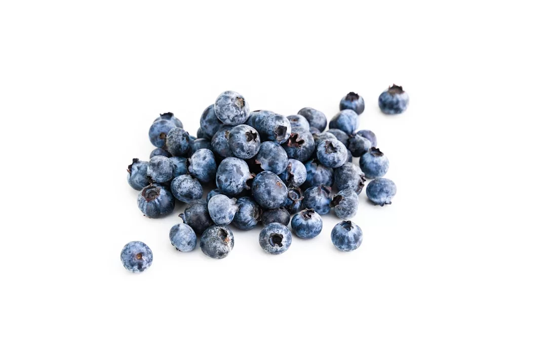 Auf weißem Hintergrund ist ein Haufen frischer Blaubeeren zu sehen, der an die lebhaften Märkte Mallorcas erinnert.
