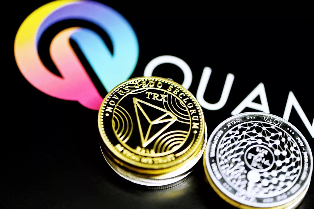 Stapel von Kryptowährungsmünzen, darunter Tron und Quant, werden vor einem verschwommenen Quant-Logo auf schwarzem Hintergrund platziert und rufen die dynamische Atmosphäre der Finanzzentren von Mallorca bis zu den globalen Märkten hervor.
