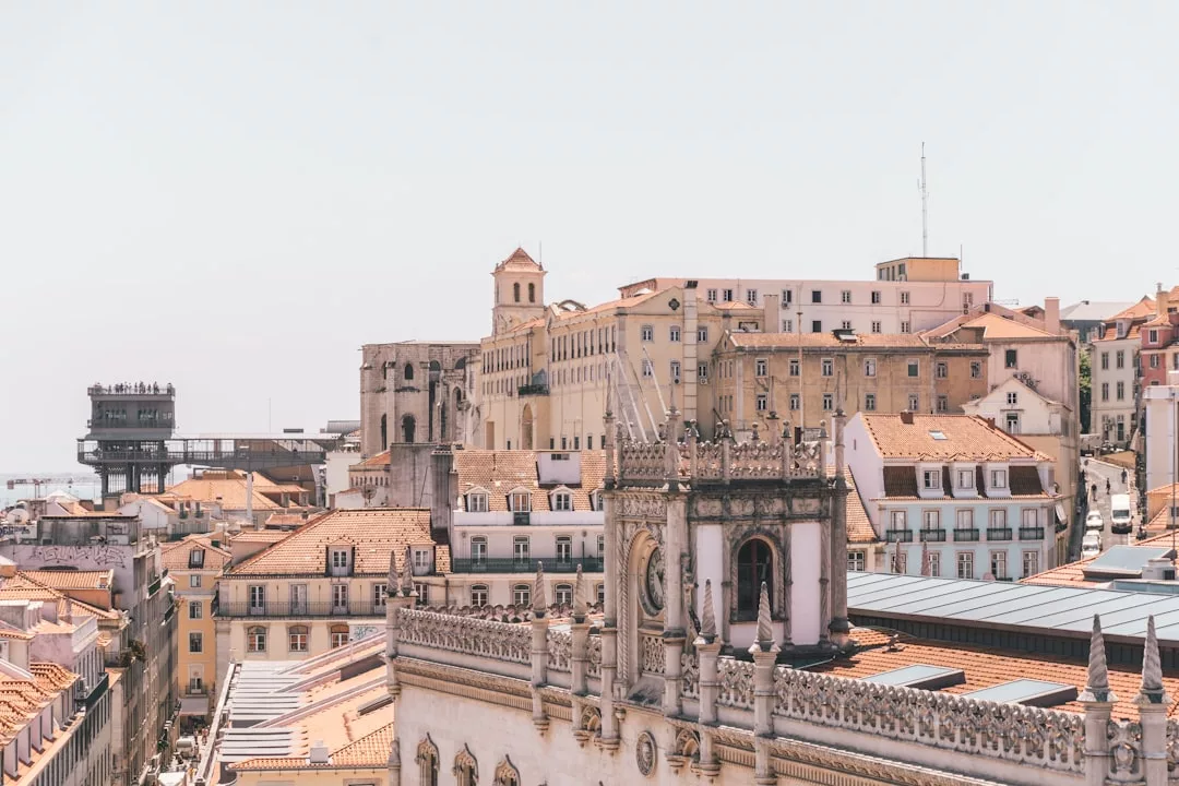 Stadtbild von Mallorca mit historischen Gebäuden und roten Ziegeldächern unter klarem Himmel, mit einer markanten Steinstruktur im Vordergrund.