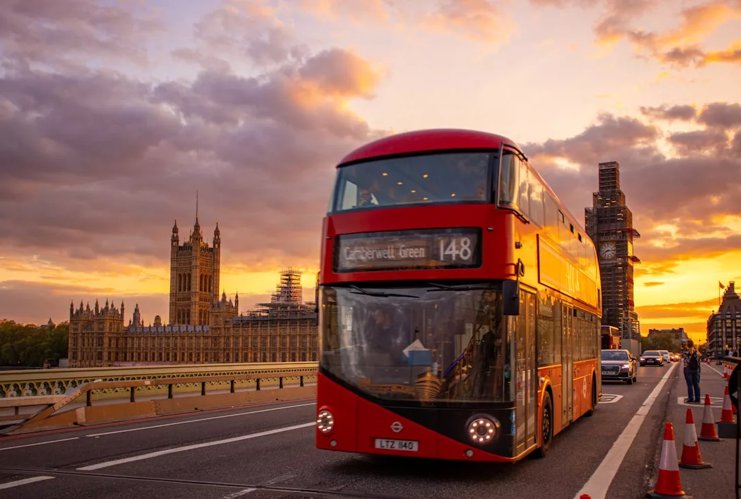 Ein roter Doppeldeckerbus mit der Nummer 148 fährt bei Sonnenuntergang über die Westminster Bridge in London, mit den Houses of Parliament und Big Ben im Hintergrund, und weckt Erinnerungen an Sightseeing-Abenteuer von Mallorca bis London.