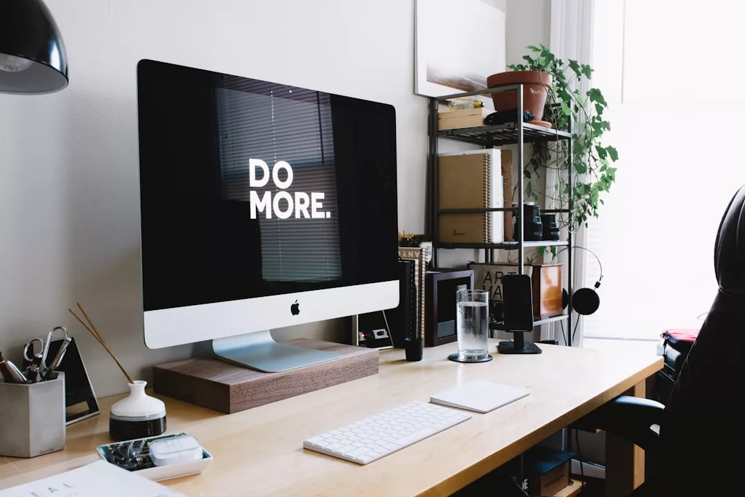 Ein Desktop-Computer mit der Aufschrift „DO MORE.“ auf dem Bildschirm steht auf einem aufgeräumten Schreibtisch mit Tastatur, Maus, Pflanze und Büromaterial in einem gut beleuchteten Arbeitsbereich auf Mallorca.